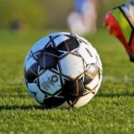 The Art of Drawing Readers In: Your attractive post title goes here Close-up of soccer ball and player's foot during match on grassy field.