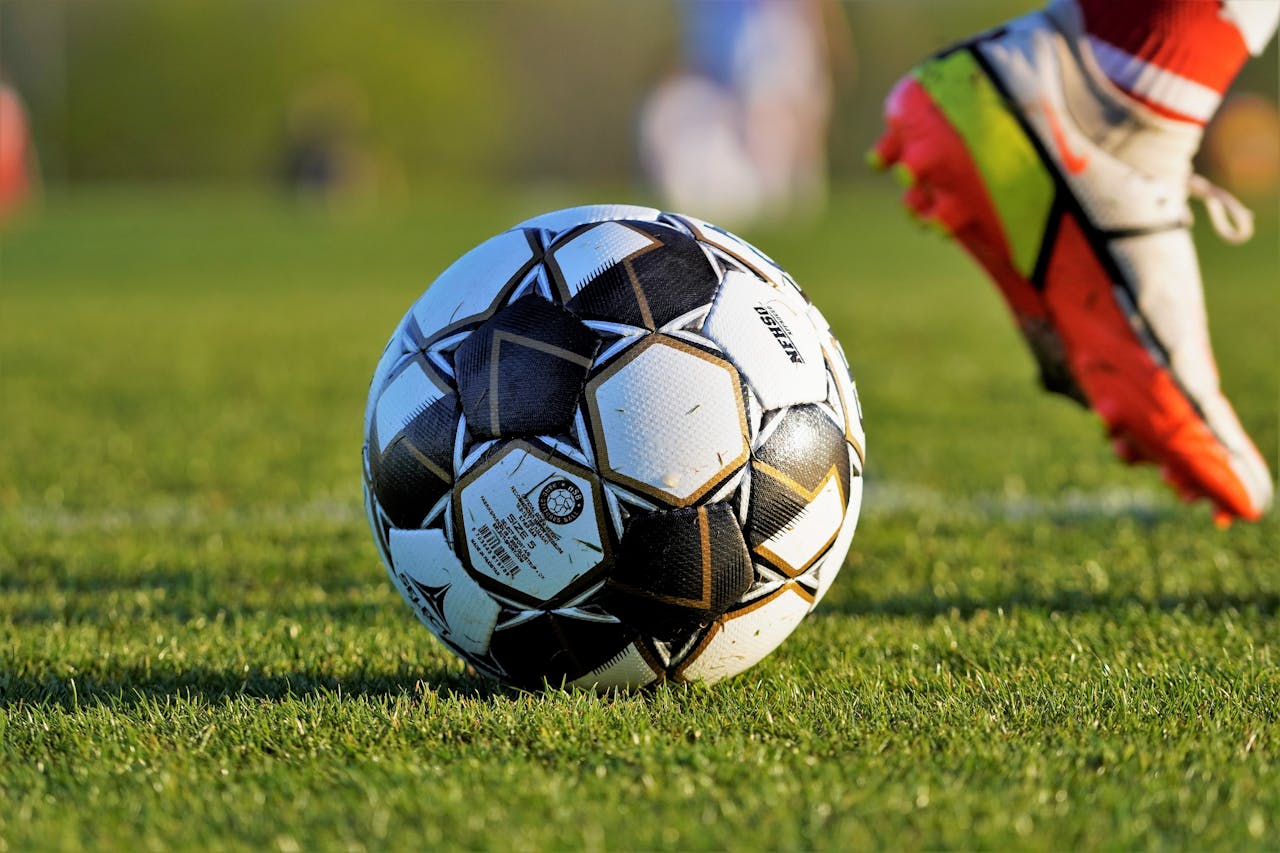 Close-up of soccer ball and player's foot during match on grassy field.